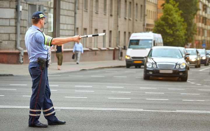A police officer is directing traffic on a city street.
