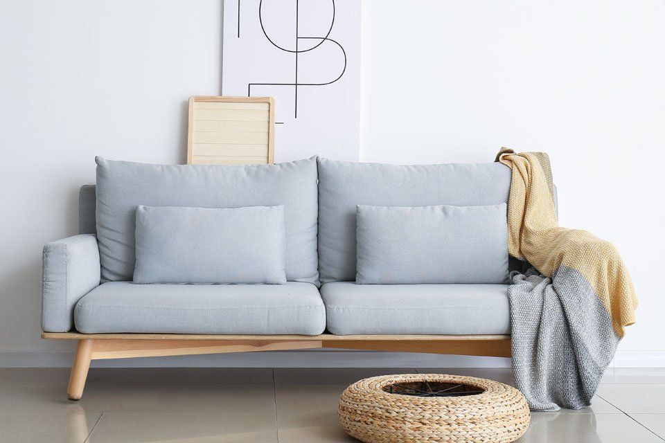 A living room with a couch and a basket on the floor.