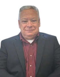 Man in a dark blazer and red shirt seated against a plain white background, smiling gently.