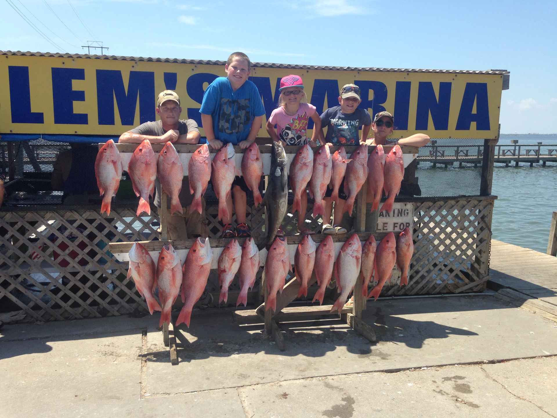 A group of people standing in front of a sign that says lem marina.