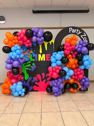 Colorful slime-themed balloon arch with “Party Zone” sign at an indoor event space