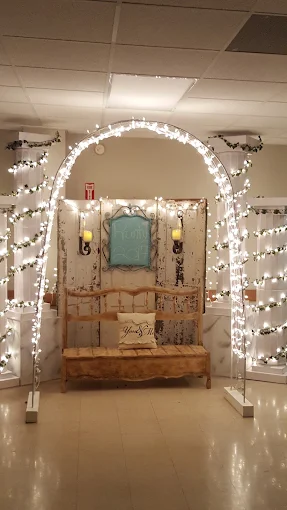 Decorative archway with white string lights framing a small wooden display in a hallway