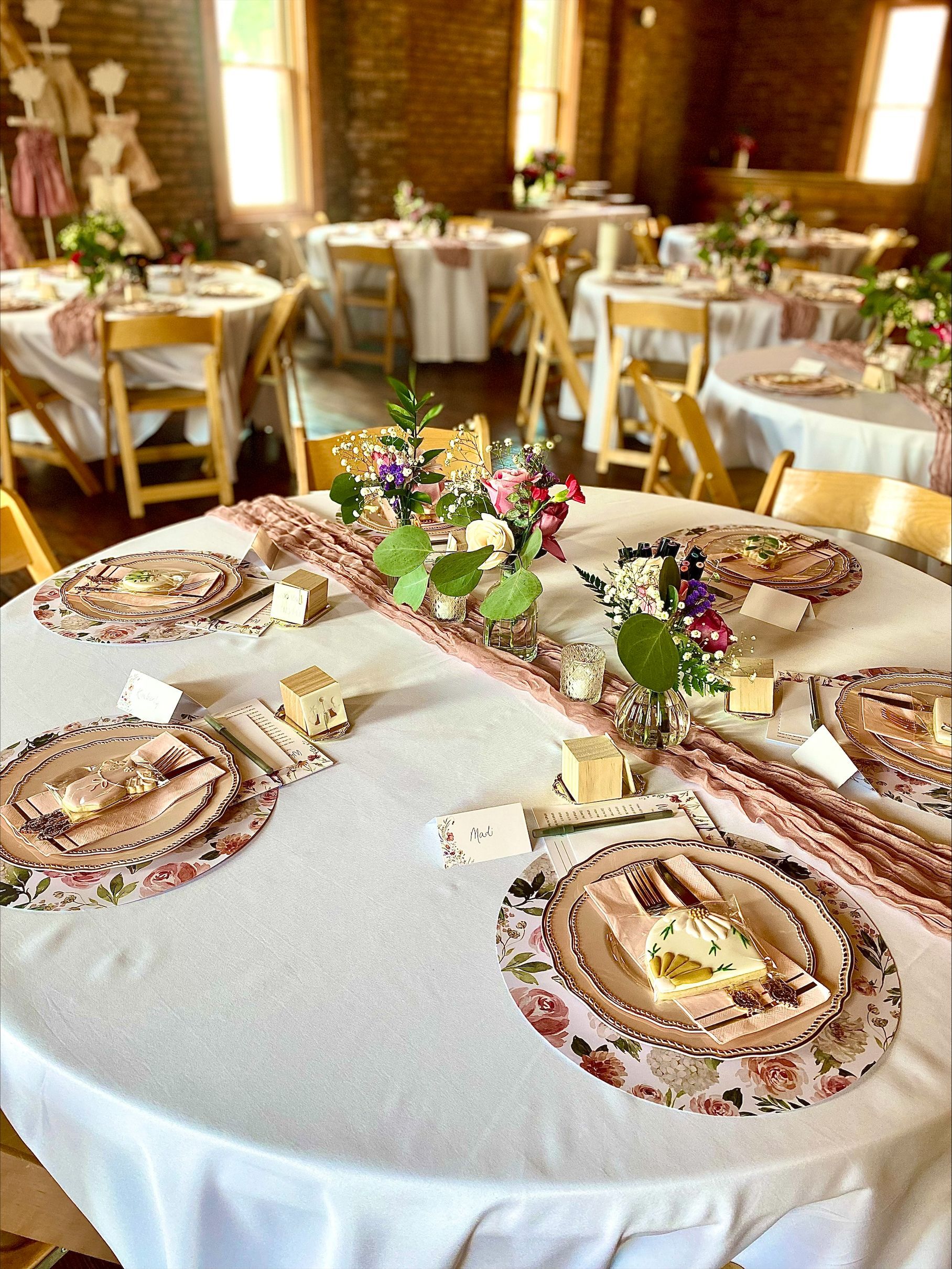 Elegant banquet table with floral centerpiece and round place settings in a warmly lit dining room