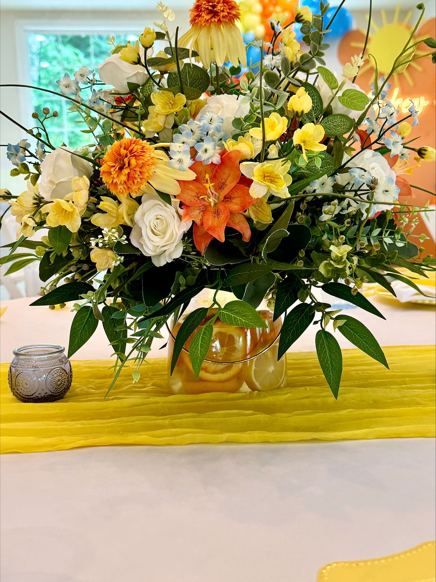 Colorful floral arrangement with orange, white, and yellow flowers on a table