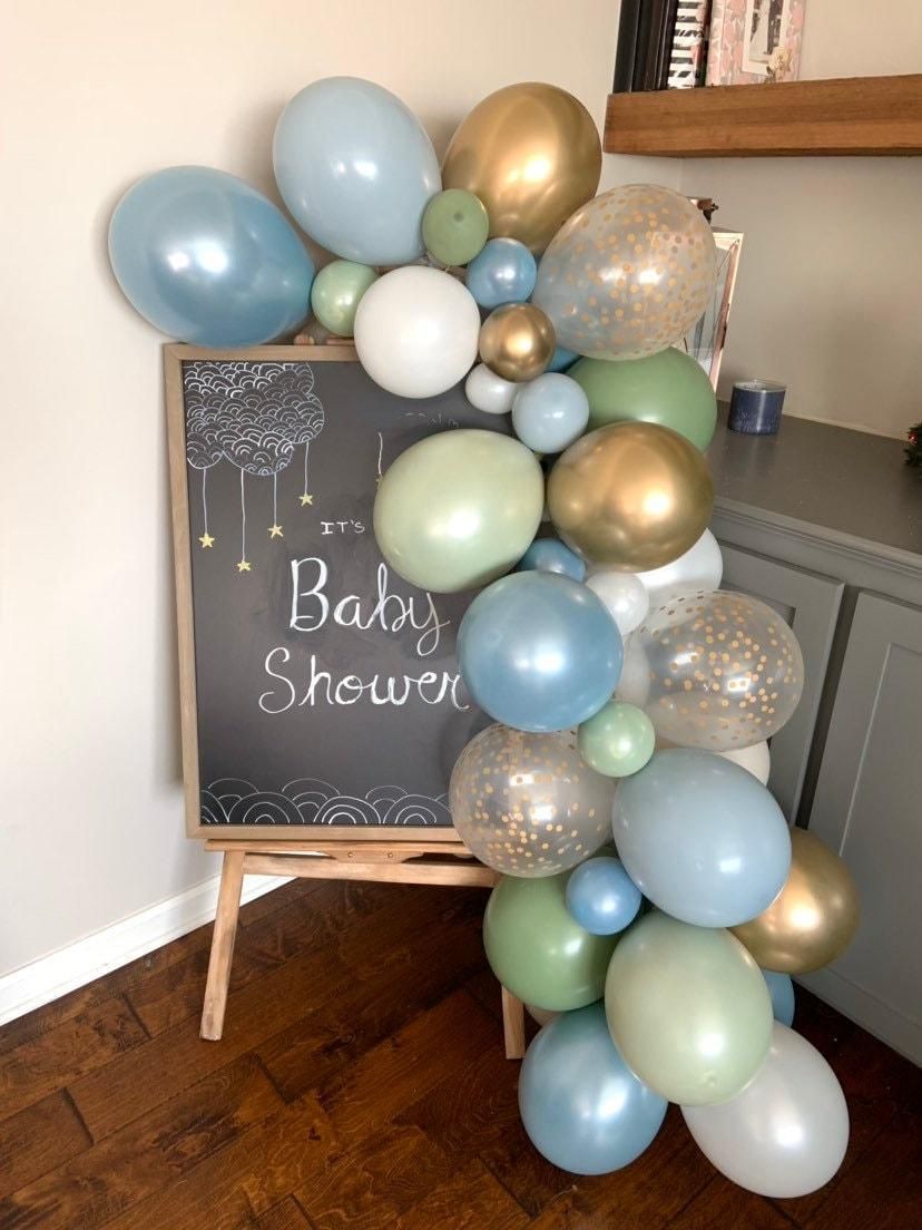 Balloon arch beside chalkboard sign reading “Baby Shower” in a decorated room