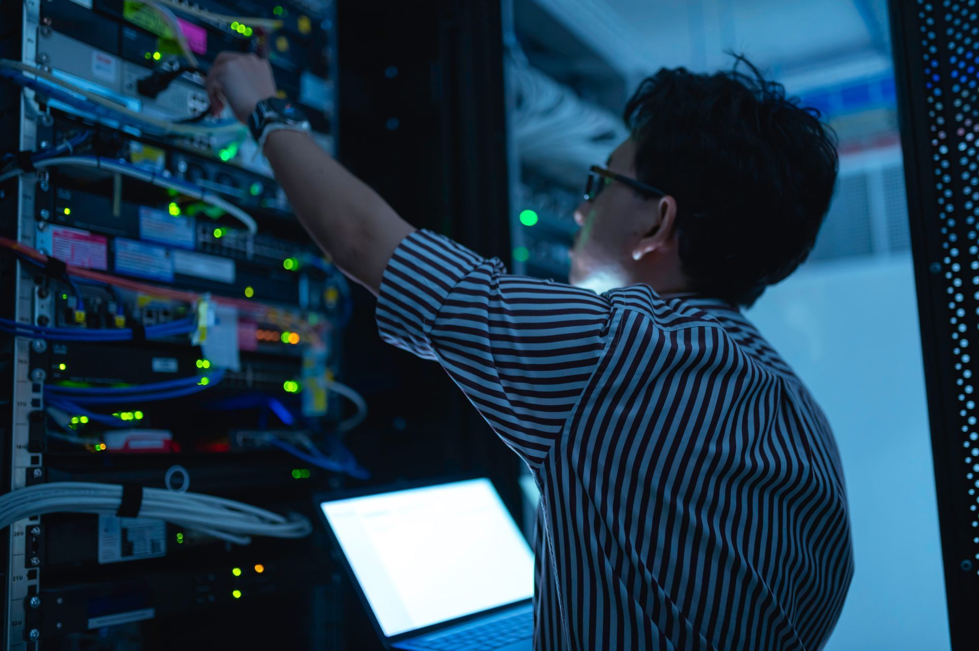 Technician Adjusting Cables in a Server Room — Pacific Telephone & Data In Cardiff, NSW