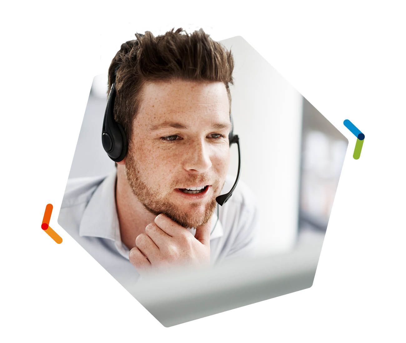 Man wearing a headset, speaking thoughtfully in a bright office setting.