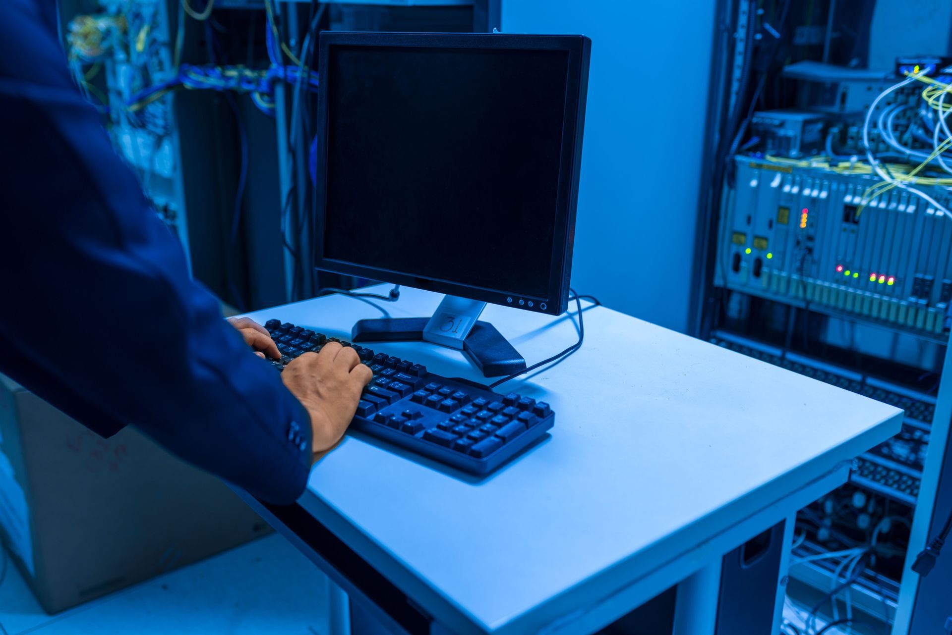 Man in Blue Blazer Typing on Laptop With Video Call Interface on Screen — Pacific Telephone & Data In Cardiff, NSW