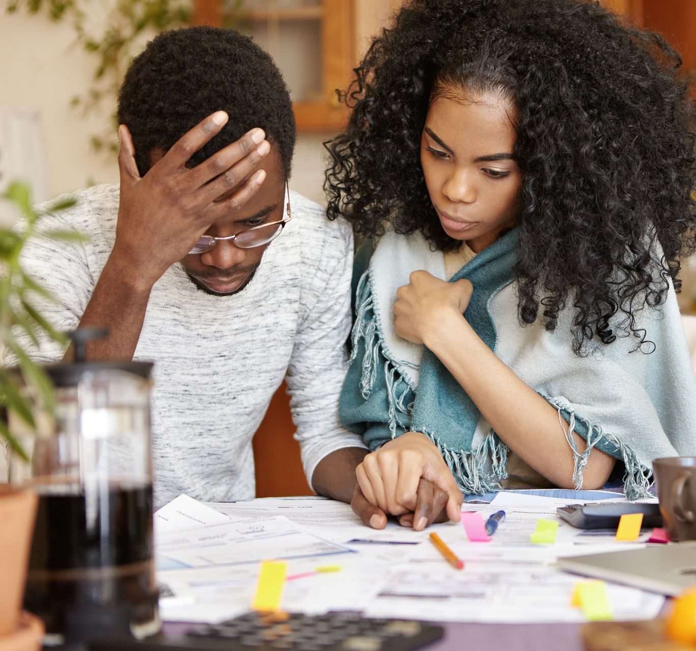 A man and a woman are sitting at a table looking at papers.