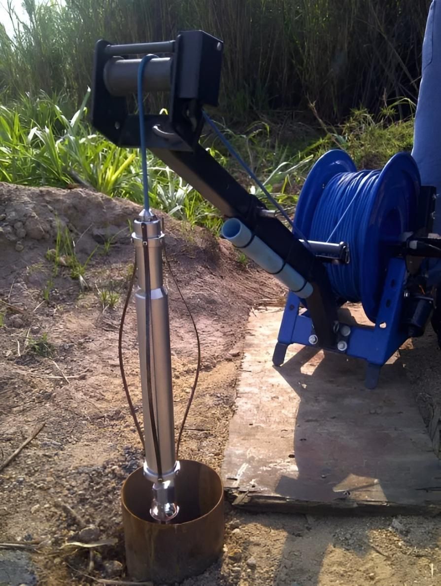 Well pump lowered into well casing with support structure, hose reel, and ground setting — Local Drilling Services In Kingaroy, QLD