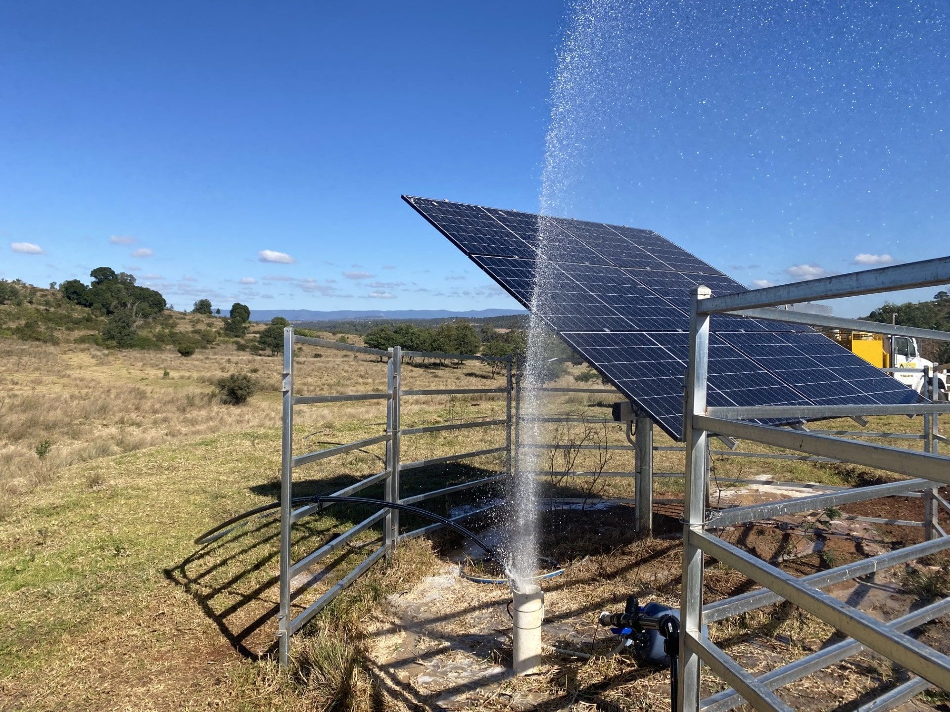 Solar panel being sprayed with water in a rural field — Local Drilling Services In Kingaroy, QLD