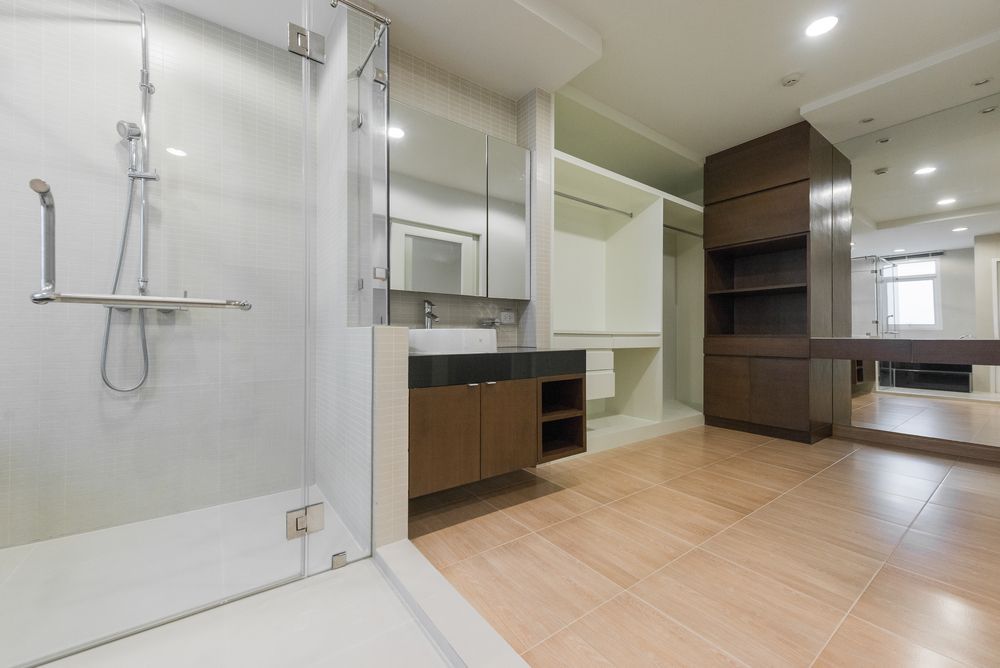 Modern bathroom with walk-in shower, vanity, wood flooring, and built-in shelving