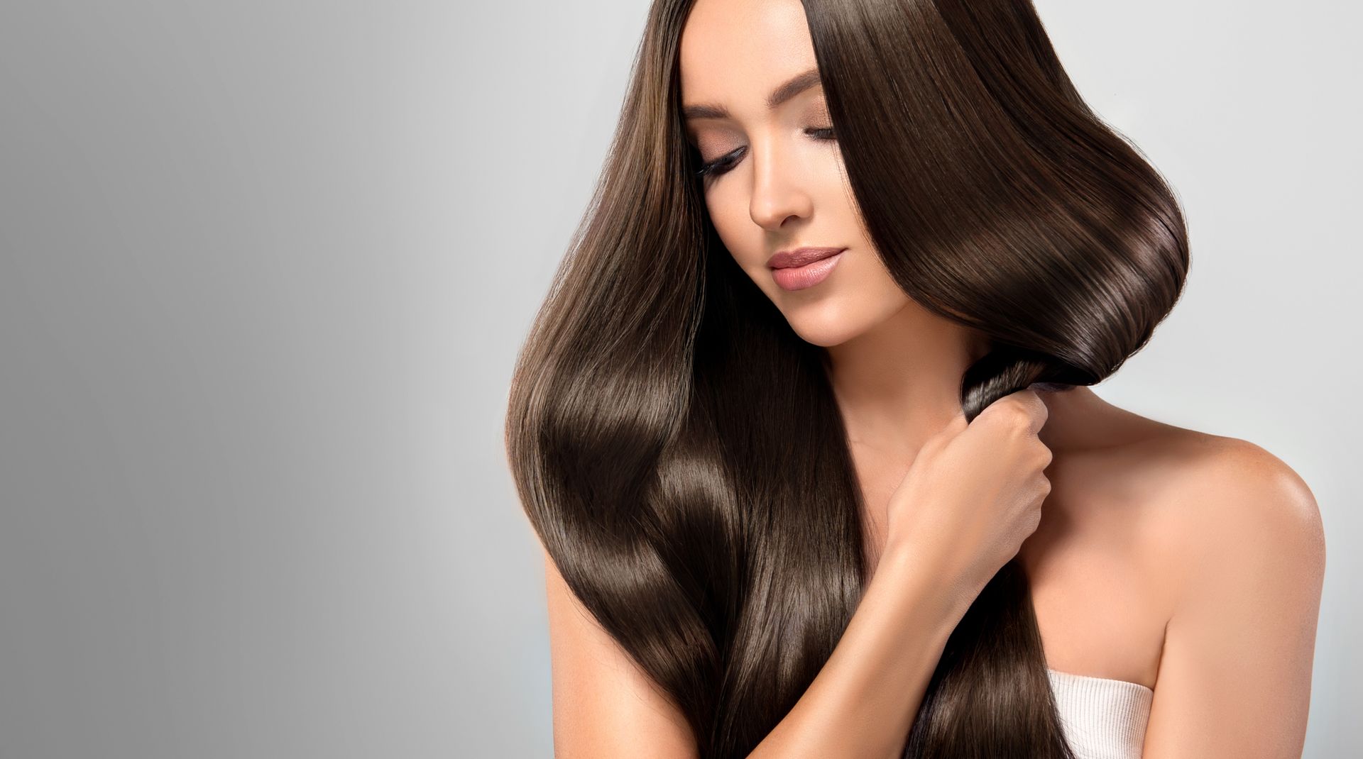 Woman With Long, Shiny, Brown Hair, Touching a Strand — Oh So Blonde Hair Studio in Buddina, QLD