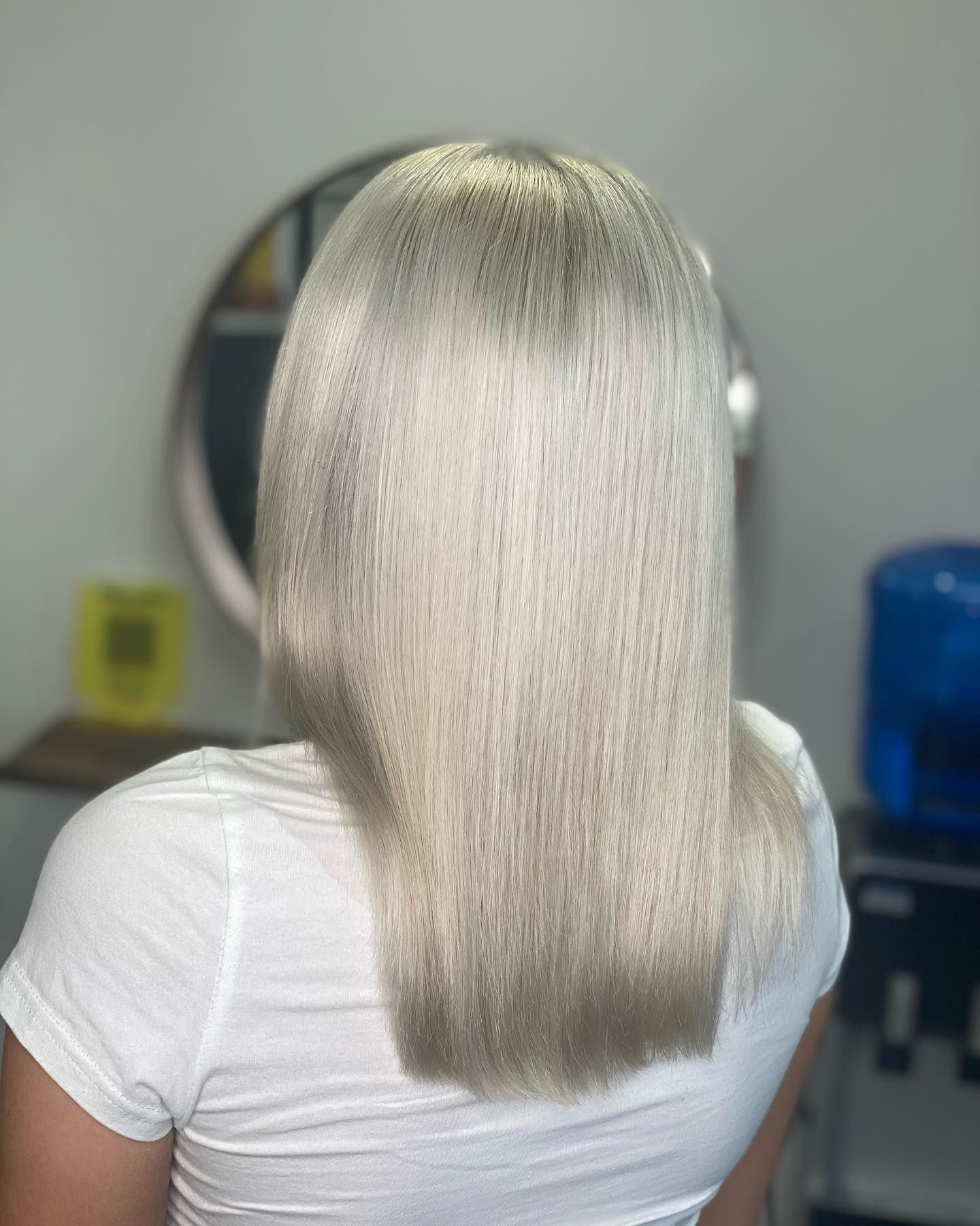 Back View Of A Person With Straight Platinum-blonde Hair Wearing A White Shirt Indoors — Oh So Blonde Hair Studio in Kawana, QLD