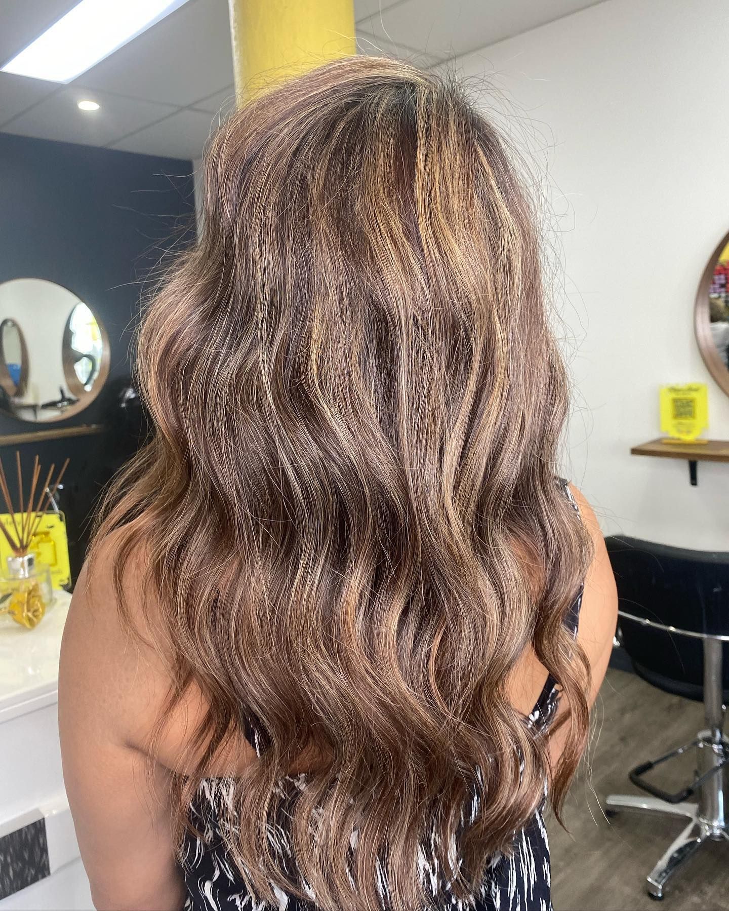 A Stylist Holds a Section of a Client's Hair — Oh So Blonde Hair Studio in Buddina, QLD