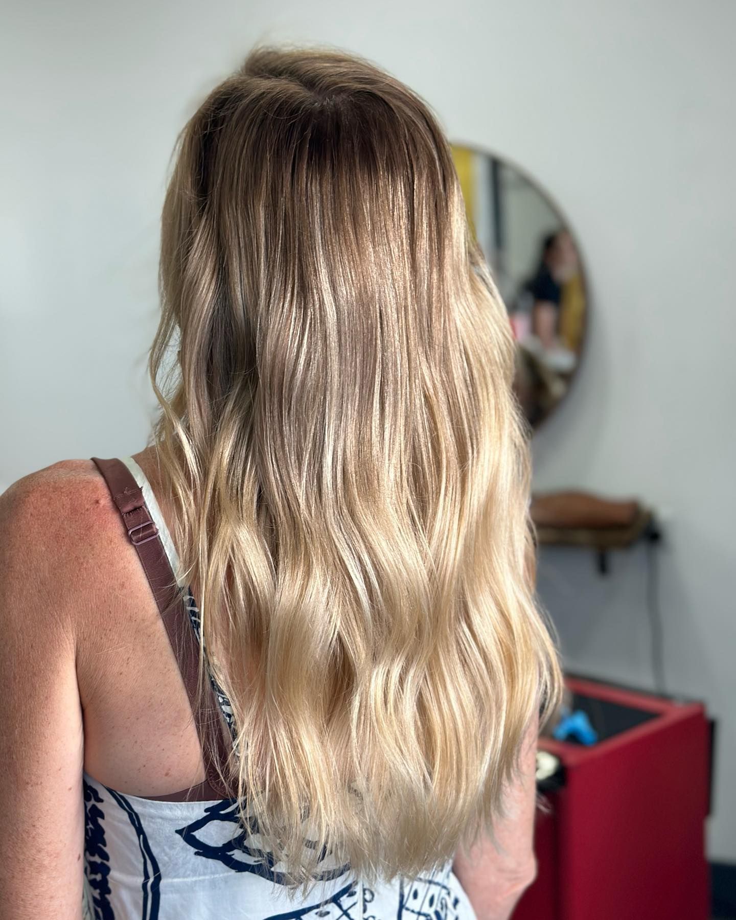 Back View Of Long Blonde Hair In A Room With A Round Mirror And Red Bin — Oh So Blonde Hair Studio in Kawana, QLD