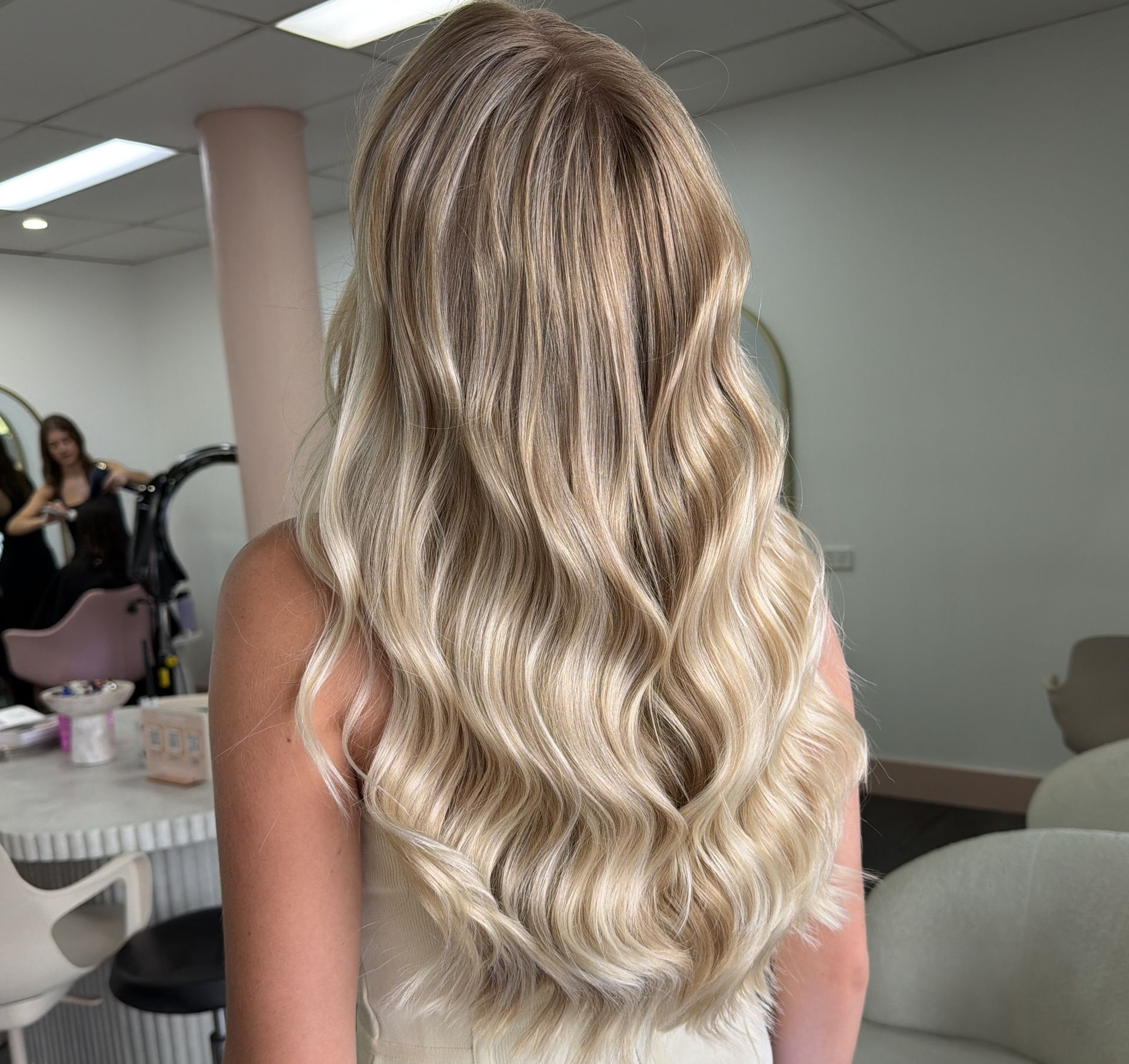 Long Wavy Blonde Hair Seen From Behind In A Salon Mirror — Oh So Blonde Hair Studio in Kawana, QLD