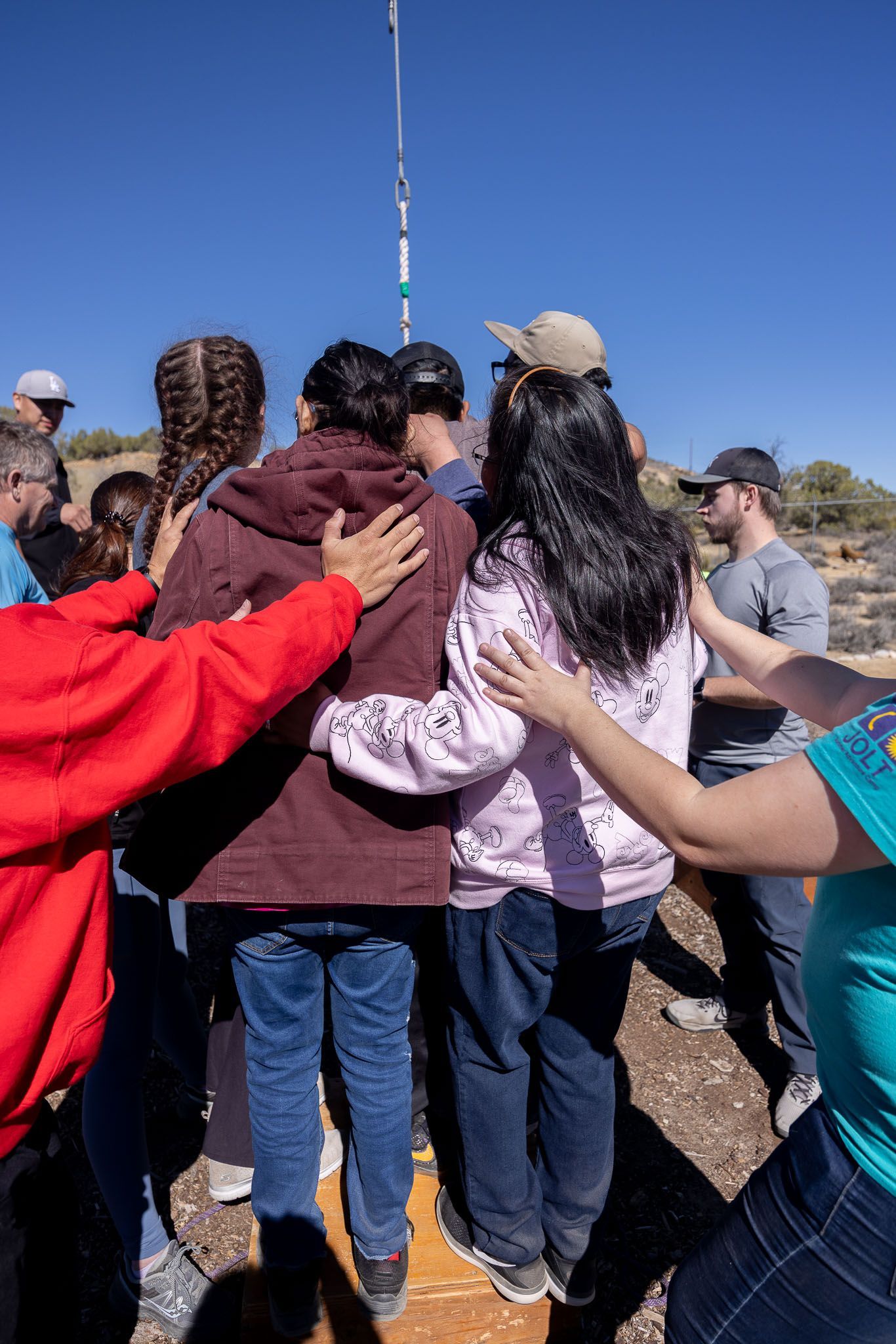 Group of teens in a circle with a person holding a clipboard, discussing in a room. Group of teens in a circle with a person holding a clipboard, discussing in a room.