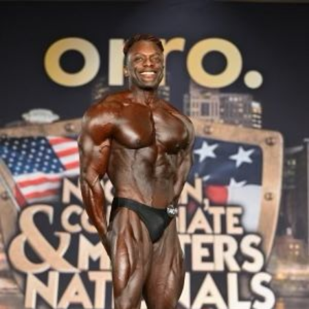 Bodybuilder in posing trunks, flexing muscles onstage at a competition.