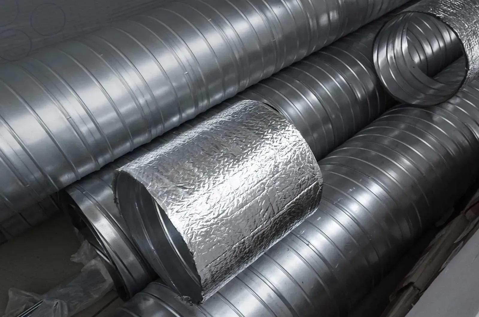 A bunch of metal pipes stacked on top of each other on a table.