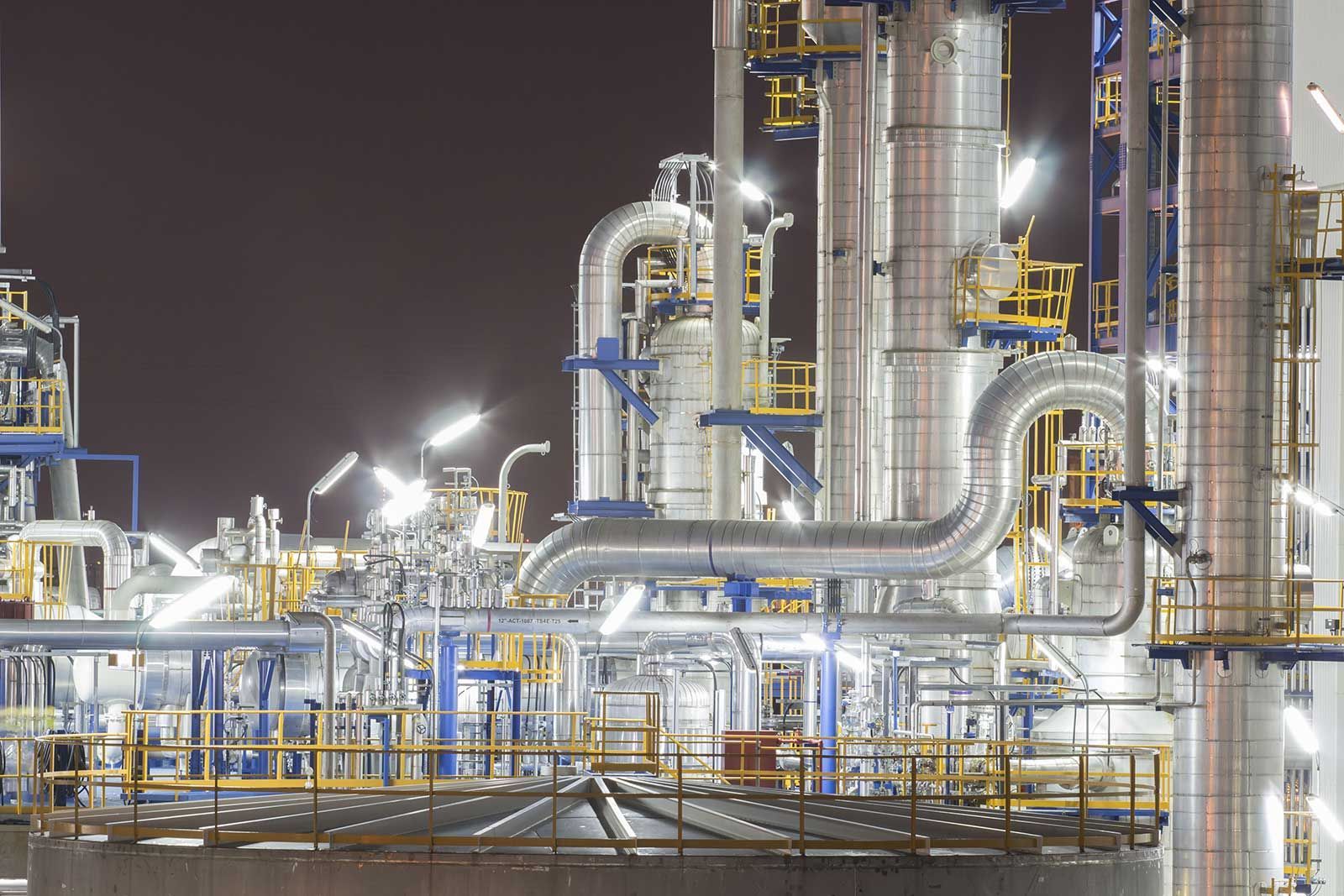 A large industrial plant is lit up at night.
