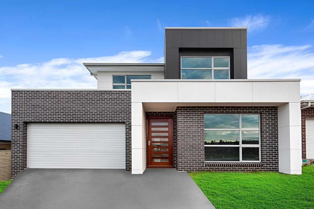The Front of a Modern House With a White Garage Door — Let's Paint & Decorate Pty Ltd in Oak Flats, NSW