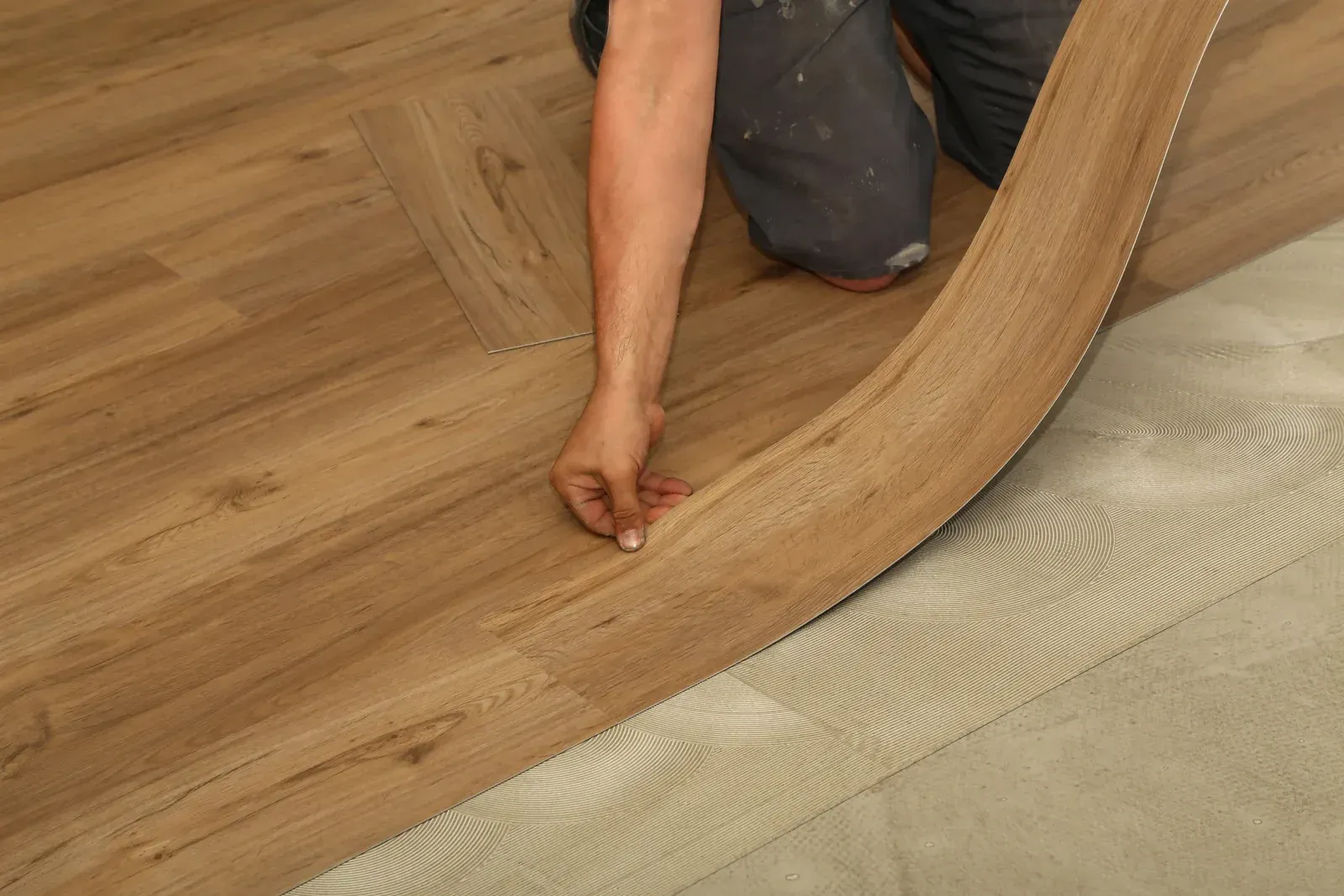 A person is installing a wooden floor in a room.