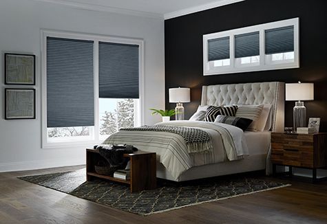 a bedroom with a bed , nightstand , lamps and a window .