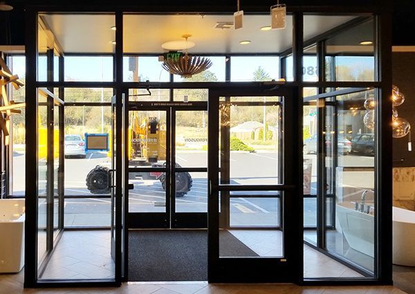 A large glass door is open in a building with a lot of windows.