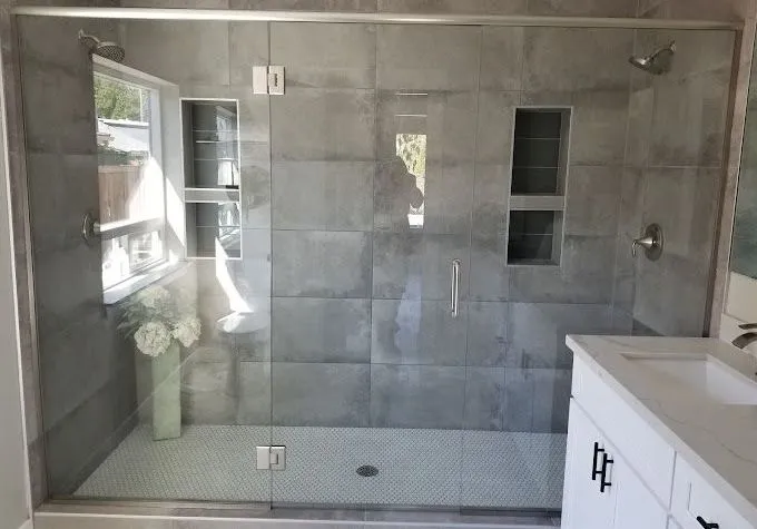 A bathroom with a walk in shower and a sink