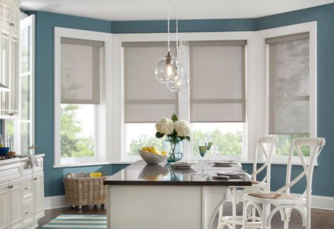 a kitchen with a table and chairs and a window with blinds .
