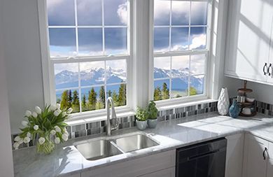 A kitchen with a sink and a window with a view of the mountains.