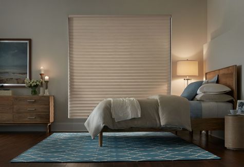 a bedroom with a bed , dresser , nightstand and rug .