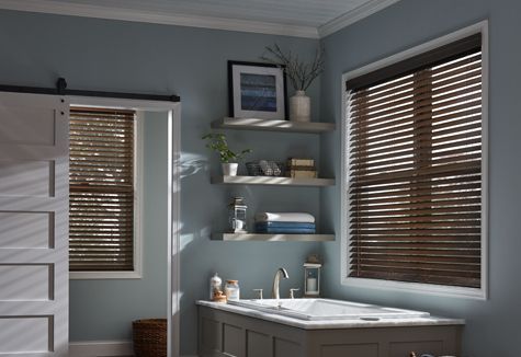 a bathroom with a tub and a window with blinds
