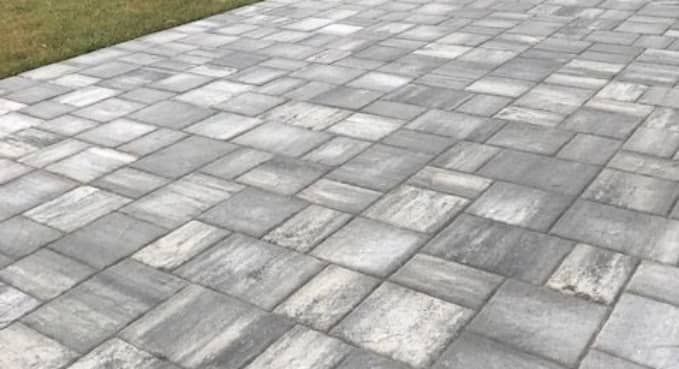 Gray stone paving tiles arranged in a staggered pattern outdoors