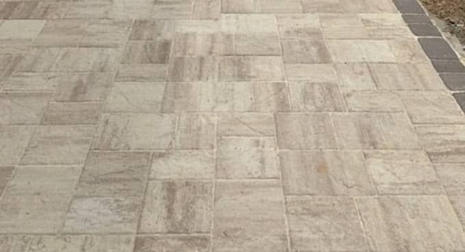 Beige tiled pavement with a dark border along the right edge.