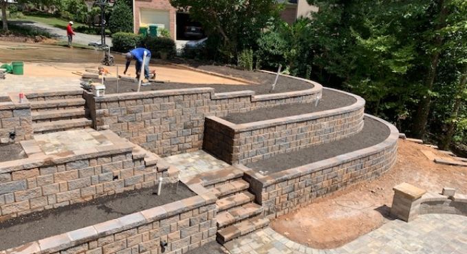 Stone terraced amphitheater with curved steps and a few people working in the background
