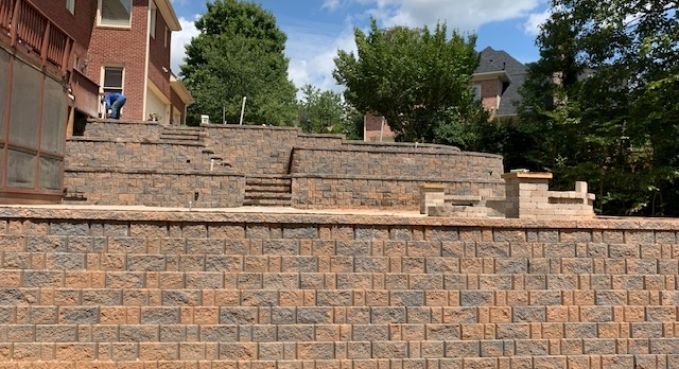 Stone terraced stairs beside a brick building and trees on a sunny day
