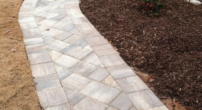 Curved stone garden path bordered by mulch and bare soil