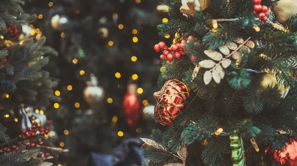 Christmas tree decorated with red baubles, pinecones, and warm twinkling lights