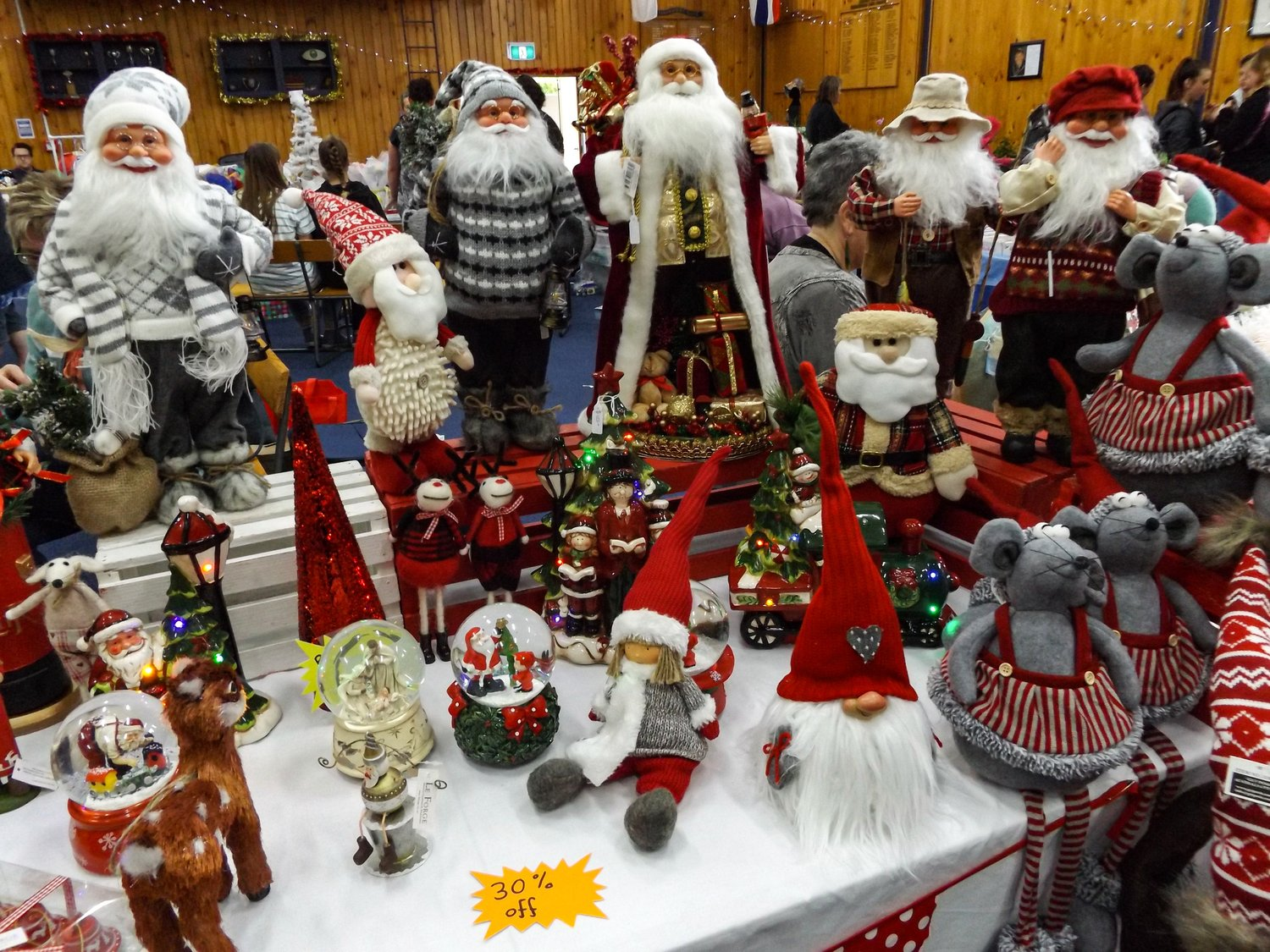 Holiday market table filled with assorted Santa, snowman, and reindeer figurines and ornaments