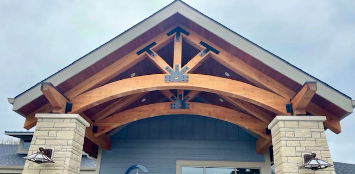 the front of a building showing an exposed decorative wooden truss