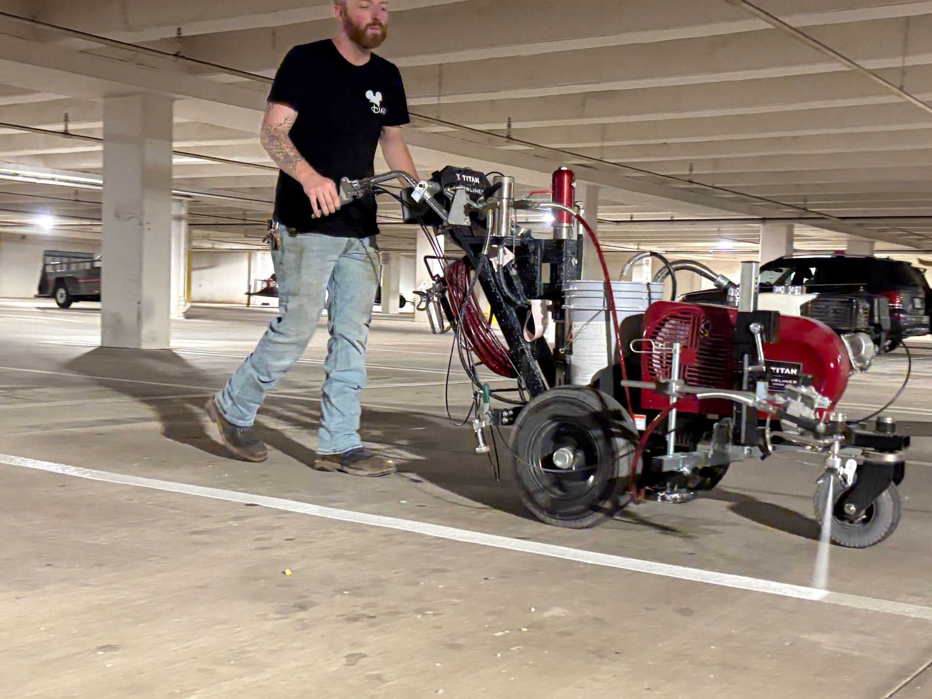 Man standing beside a red motorized trike in a parking garage
