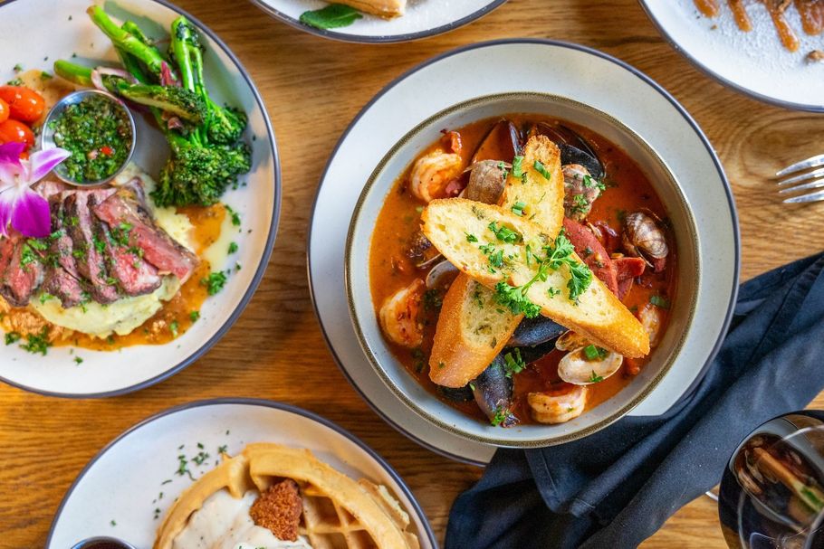 A table topped with plates of food and a bowl of soup.
