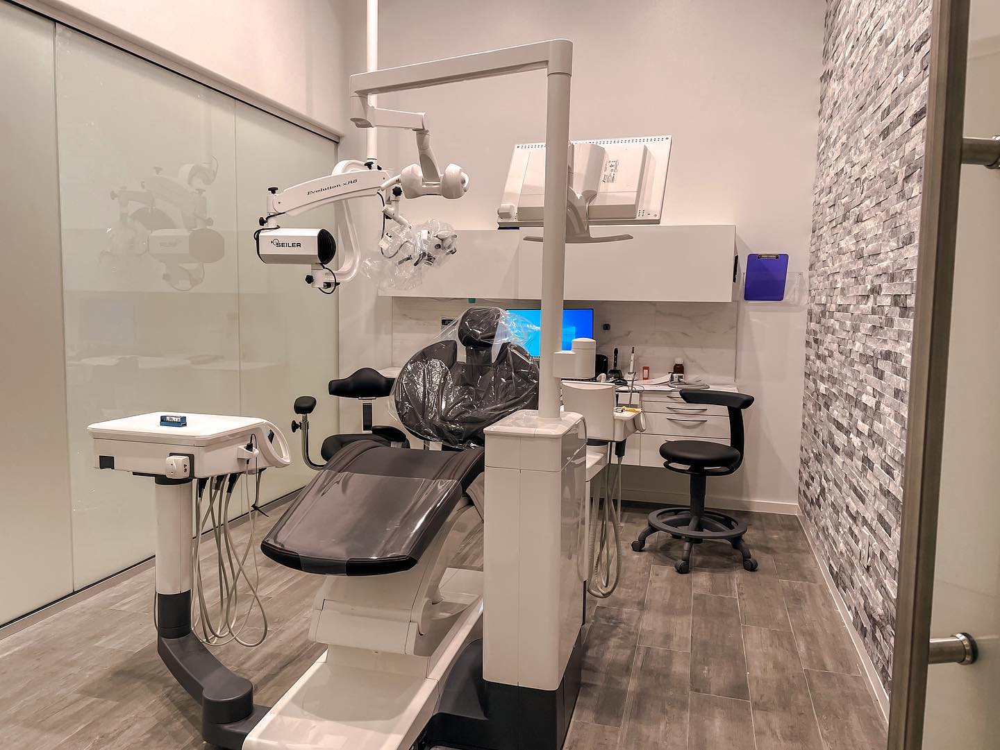 A dental office with a dental chair and a microscope.