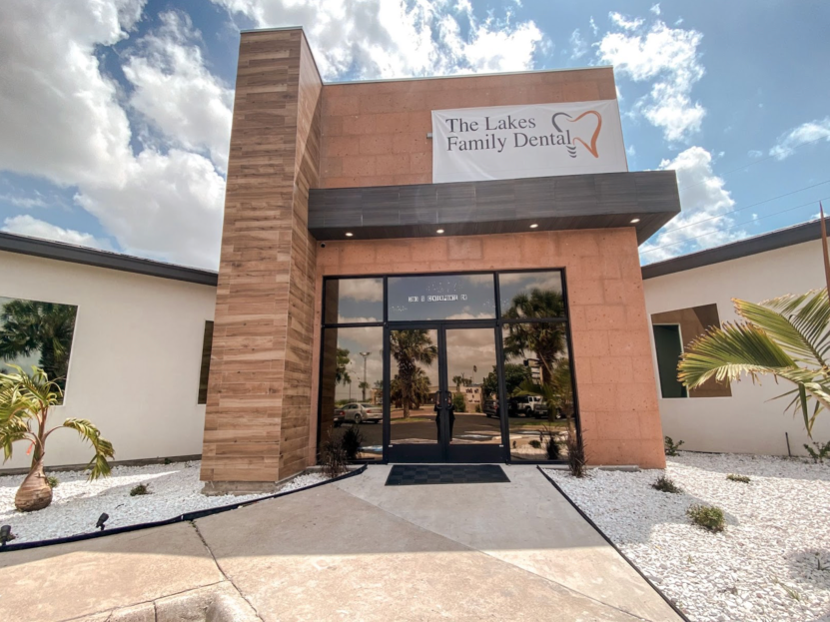 The front of a dental office with a sign that says the lakes family dental