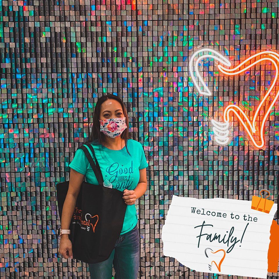 A woman wearing a face mask is standing in front of a wall.
