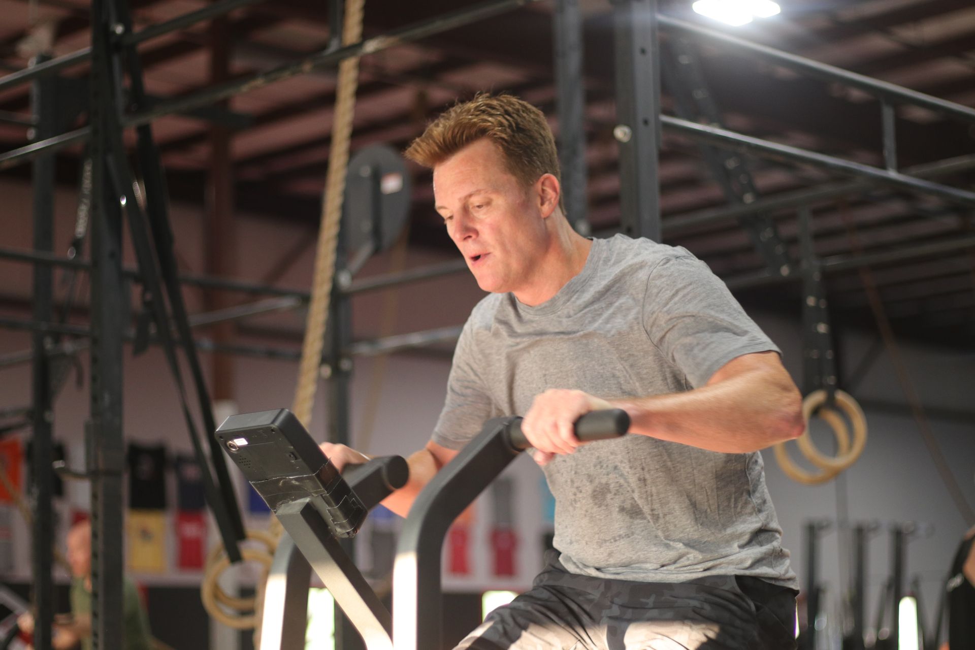 A woman is squatting with a barbell over her head in a gym.