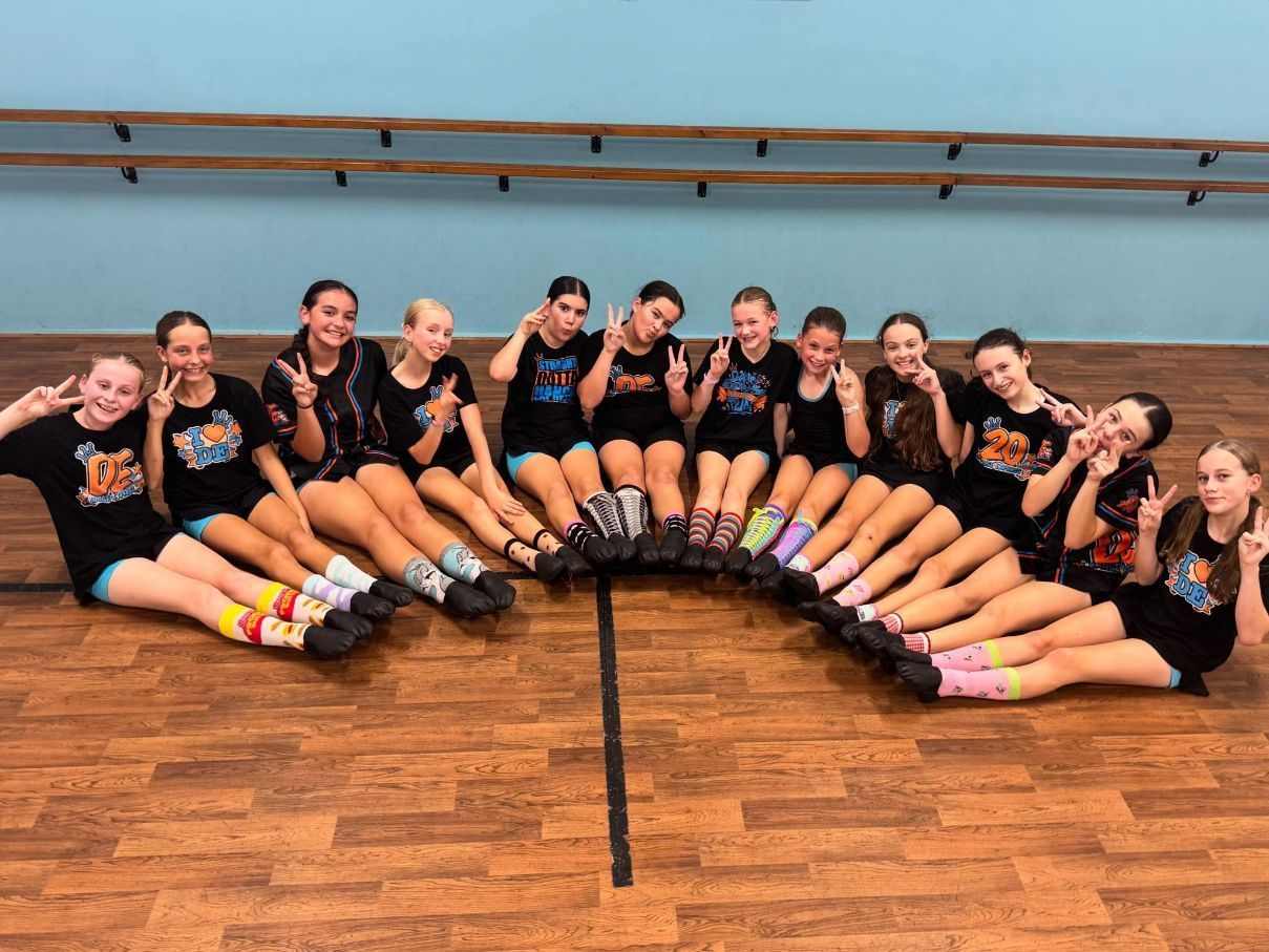 A Group Of Young Girls Are Sitting In A Circle On The Floor In A Dance Studio — Dance Express Mackay In North Mackay, QLD