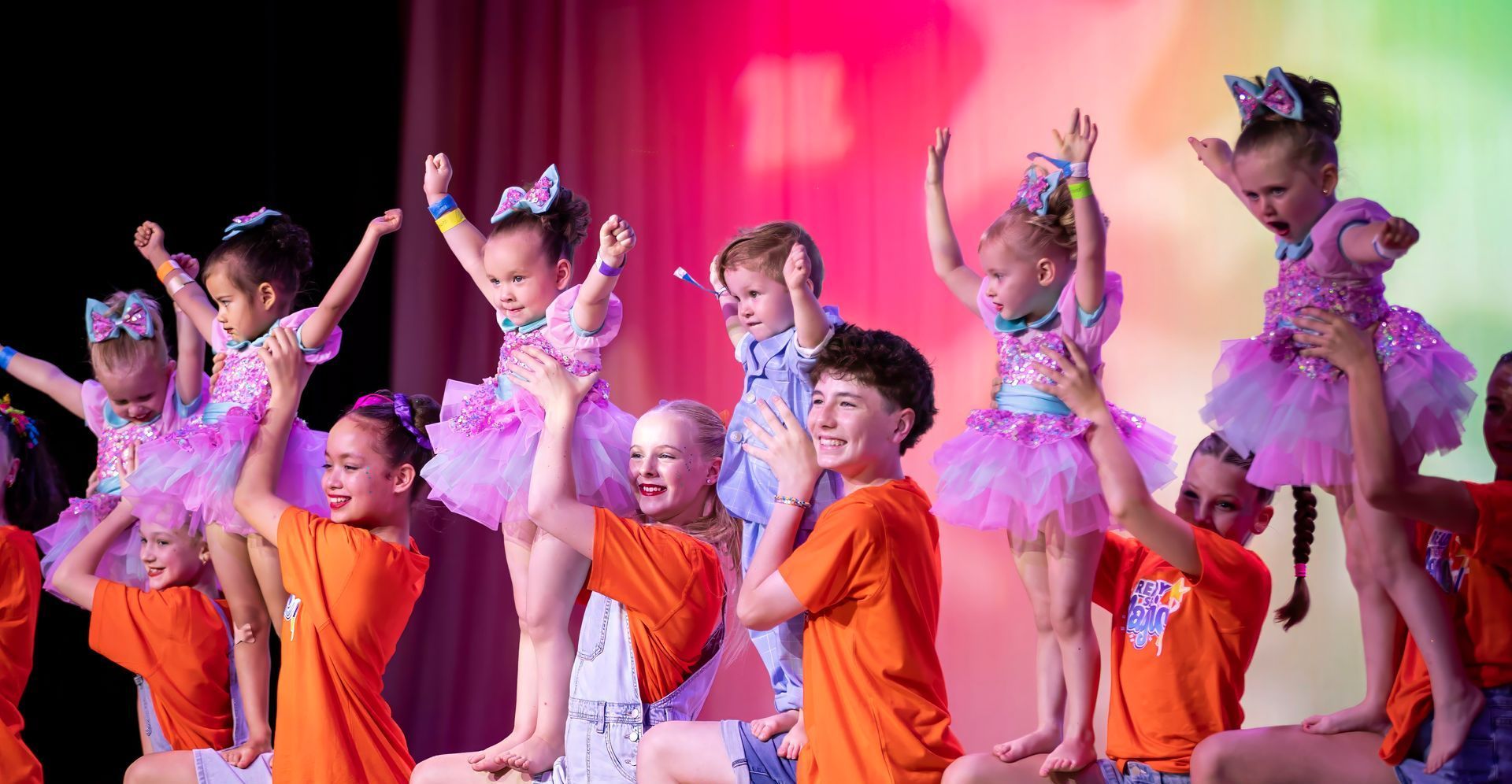 A woman is kneeling next to a little girl on a mat in a gym — Dance Express Mackay In North Mackay, QLD